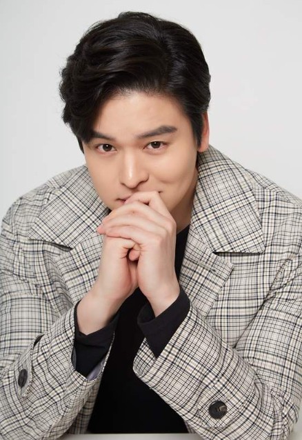 이장우가-체크-코트를-입고-양손으로-턱을-괴고-있다