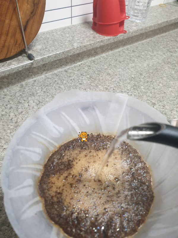 드리퍼의 라이언 스티커가 있는 수위를 보며 수위가 일정하게 되도록 푸어하는 모습