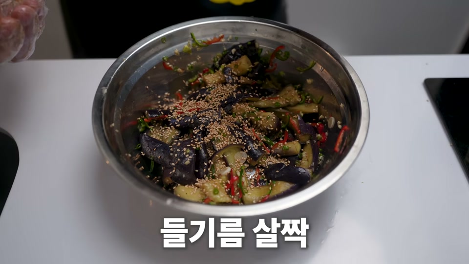 깨와 들기름을 더해 마무리 버무리는 장면