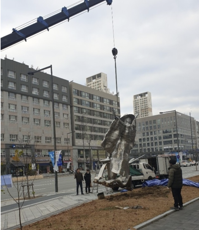 크레인이 조형물을 들어 올리고 있다.