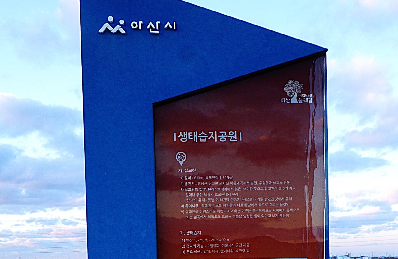 파란+붉은 바탕에 흰글씨로 생태습지 안내문,