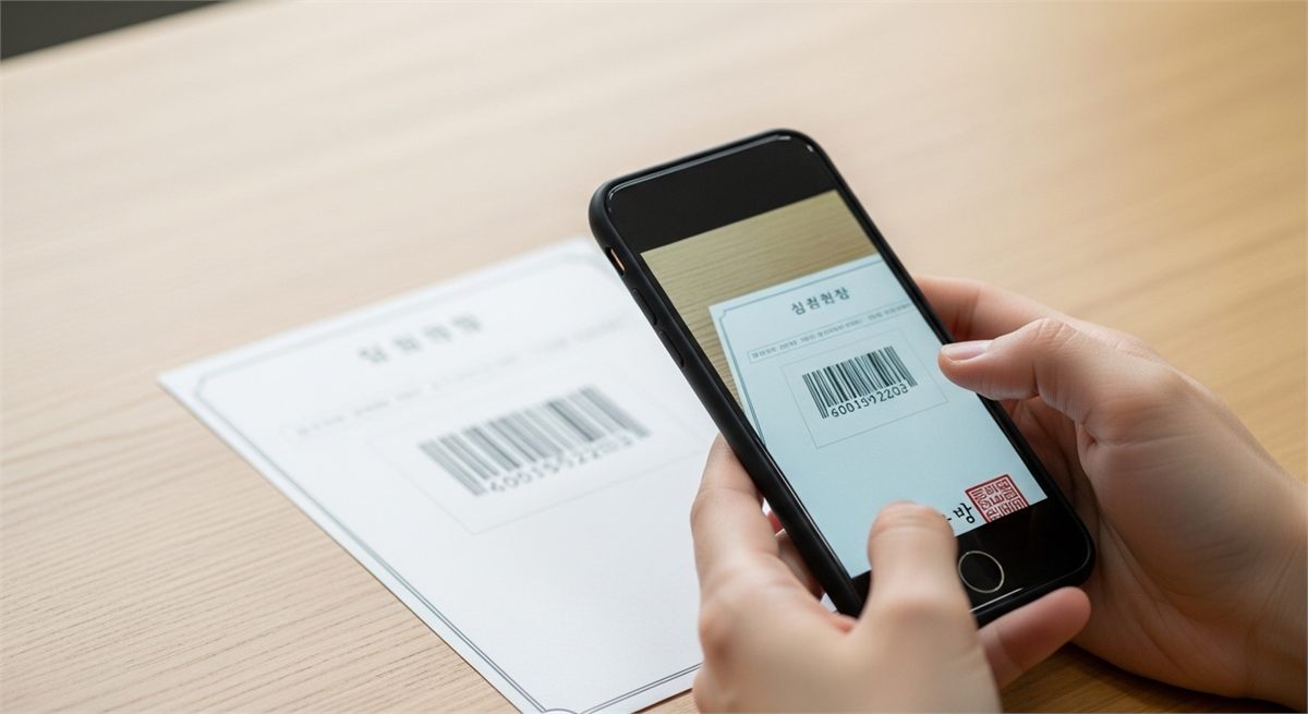 스마트폰으로 출력된 증명서의 바코드 부분을 확인하는 손 클로즈업