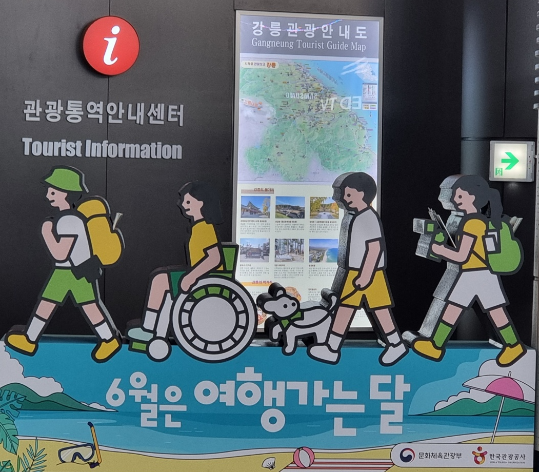 강릉역 로비에서 찍은 '6월은 여행가는 달' 상징물 사진입니디. 바다와 산의 배경 그림에 사람들이 줄지어 걸어가는 그림이에요.