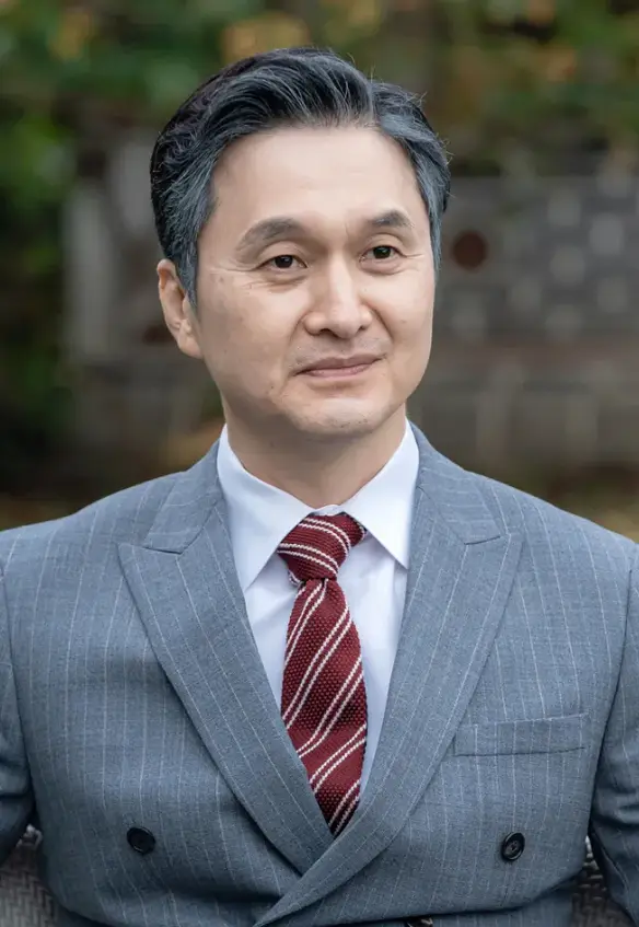 재벌X형사-
회색자켓 흰셔츠 빨간넥타이를 메고 머리가 히긋히긋한채 앞을 바라보는 진명철