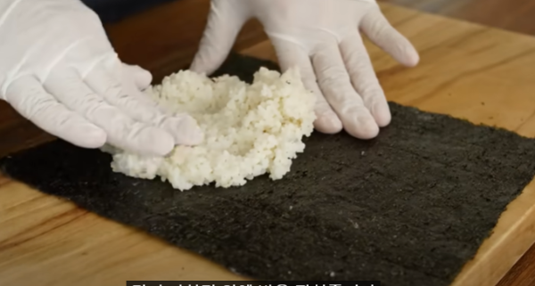 김 위에 밥을 올리고 있습니다