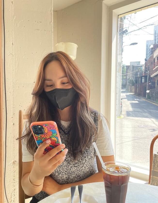 의자에앉아서-핸드폰을보고있는-긴머리여성의모습