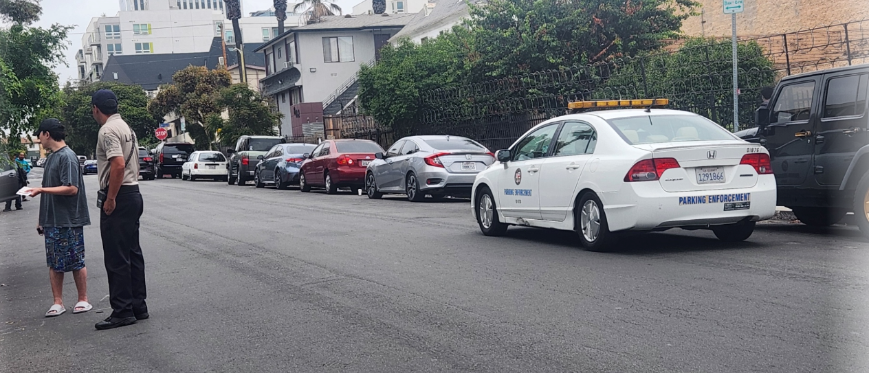 시민은 주차 단속관에게 설명을 듣거나 항의 중인 상황 이미지