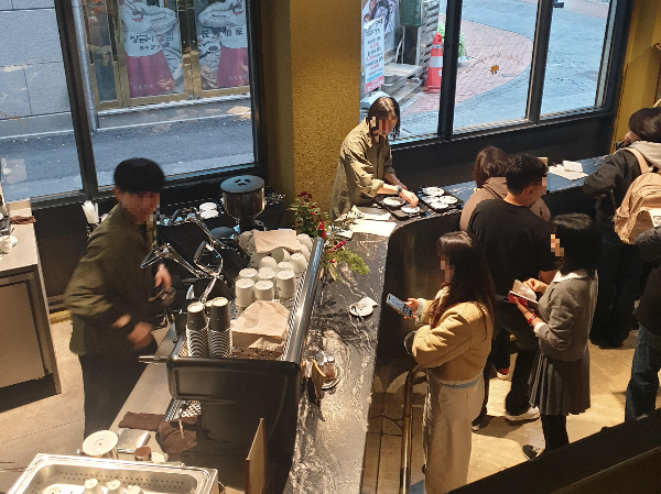 2층 올라가는 계단에서 찍은 1층 모습. 많은 손님들이 줄을 서고 있다.