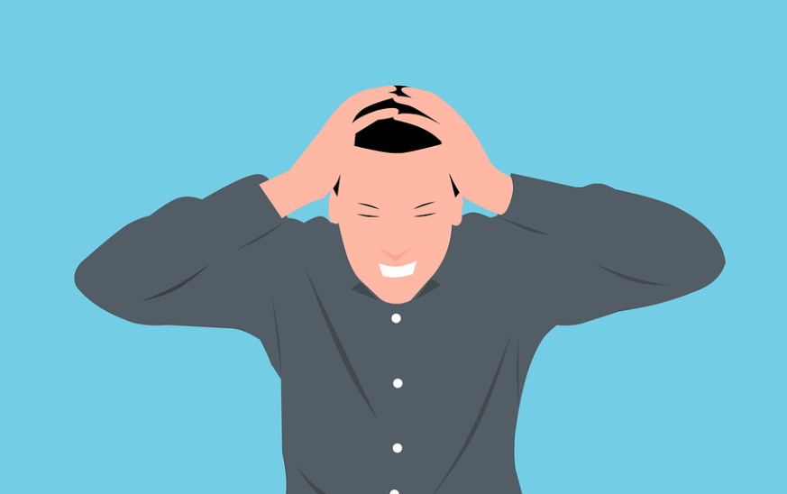 철분 부족 증상으로 두통으로 두손을 머리에 감싸고 있는 남성