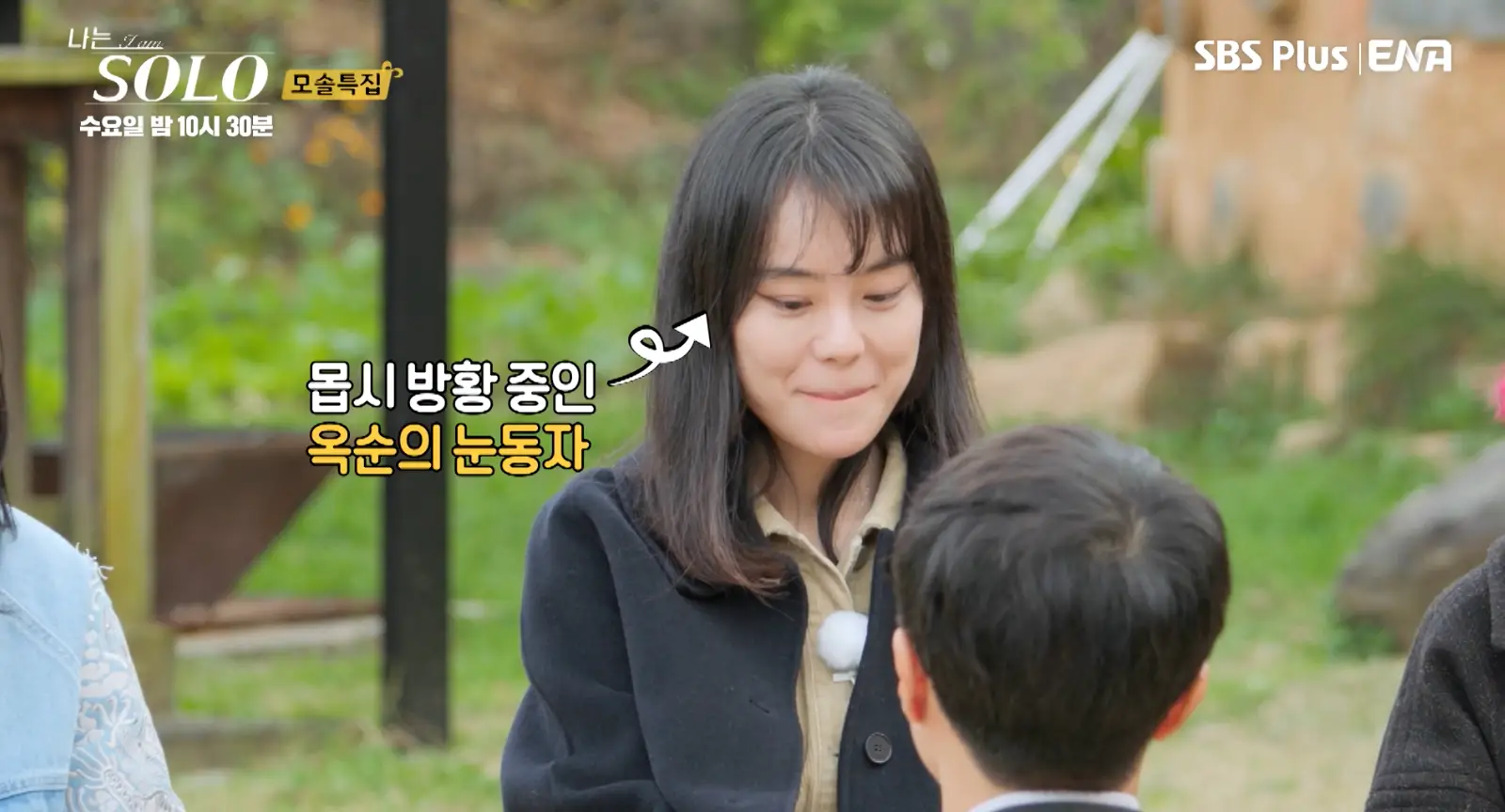 솔로- 검은 자켓 안 베이지 셔츠를 입고 긴머리를 풀어헤친채 수줍어하며 미소짓는 옥순