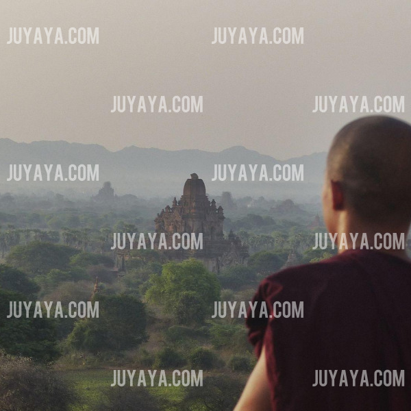 미얀마 바간의 평원을 배경으로 수도승이 사원들을 바라보는 모습.