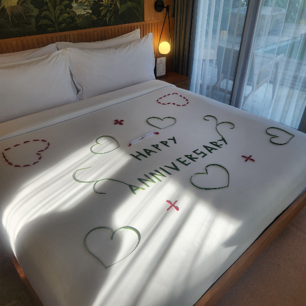 더블 침대에 환영의 데코레이션. 하트 모양과 HAPPY ANNIVERSARY 문구
