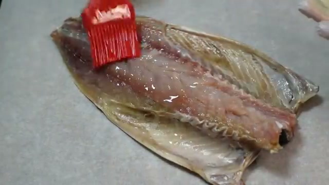 붓으로 고등어에 양념물을 바르는 장면
