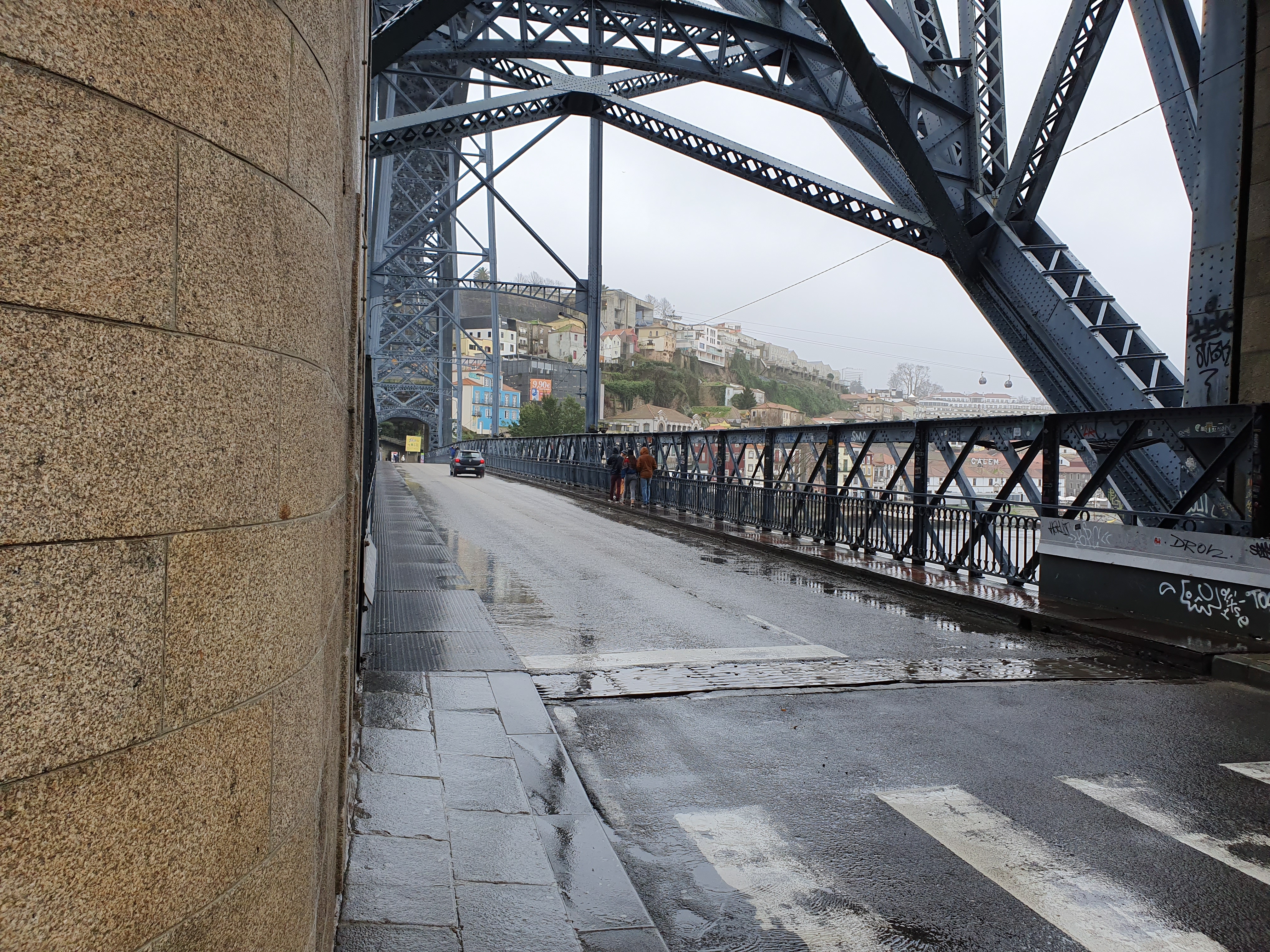 루이스 1세 다리 상부 보행로를 걷는 여행객들과 철제 아치 구조