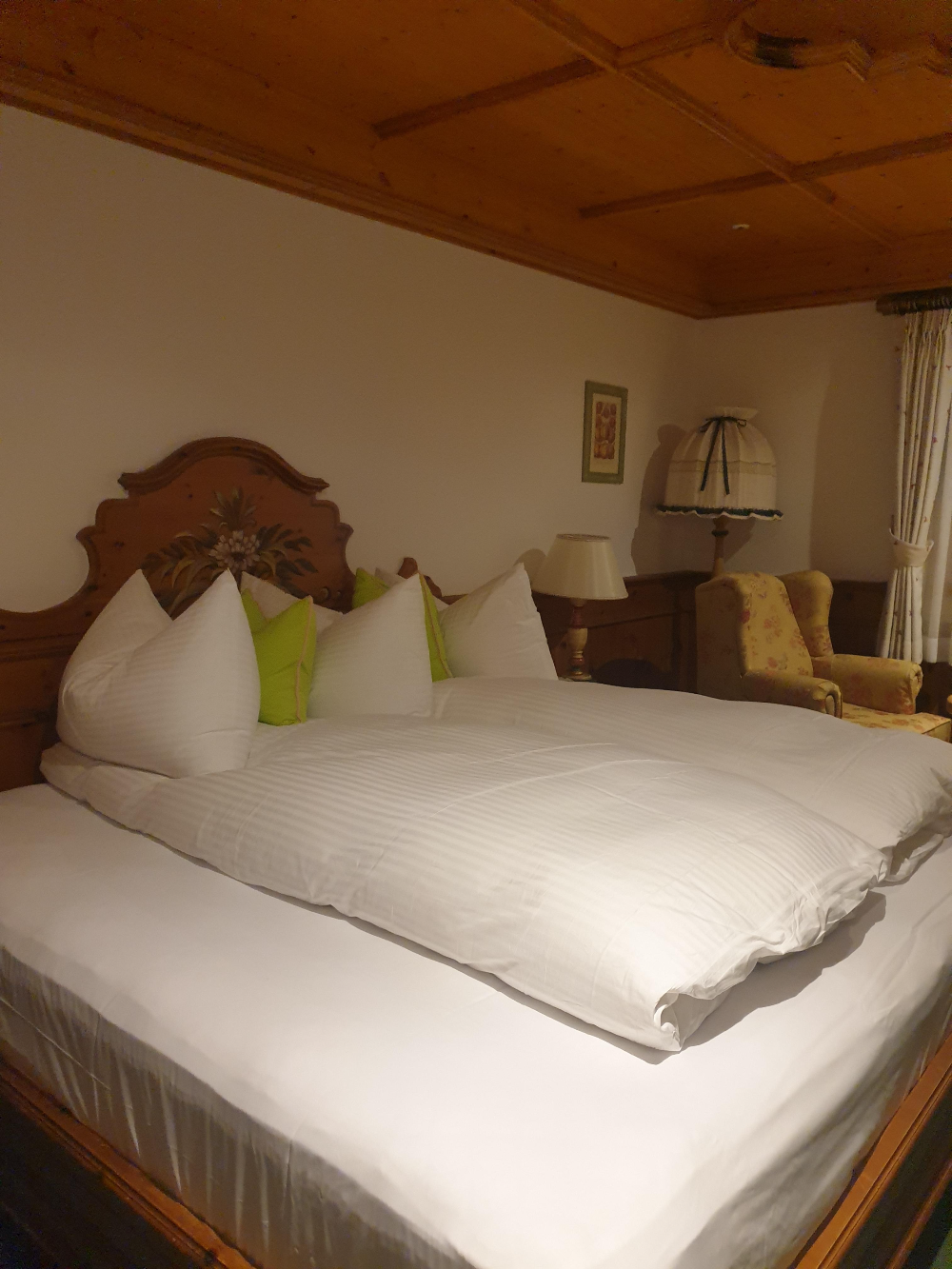 넓은 객실에 더블 침대가 놓여있다. 뒤에 조명과 큰 소파까지 객실이 넓다.