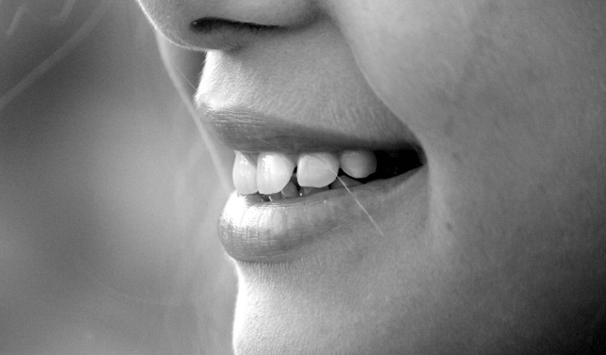 치아를 보이며 밝게 웃고 있는 여자