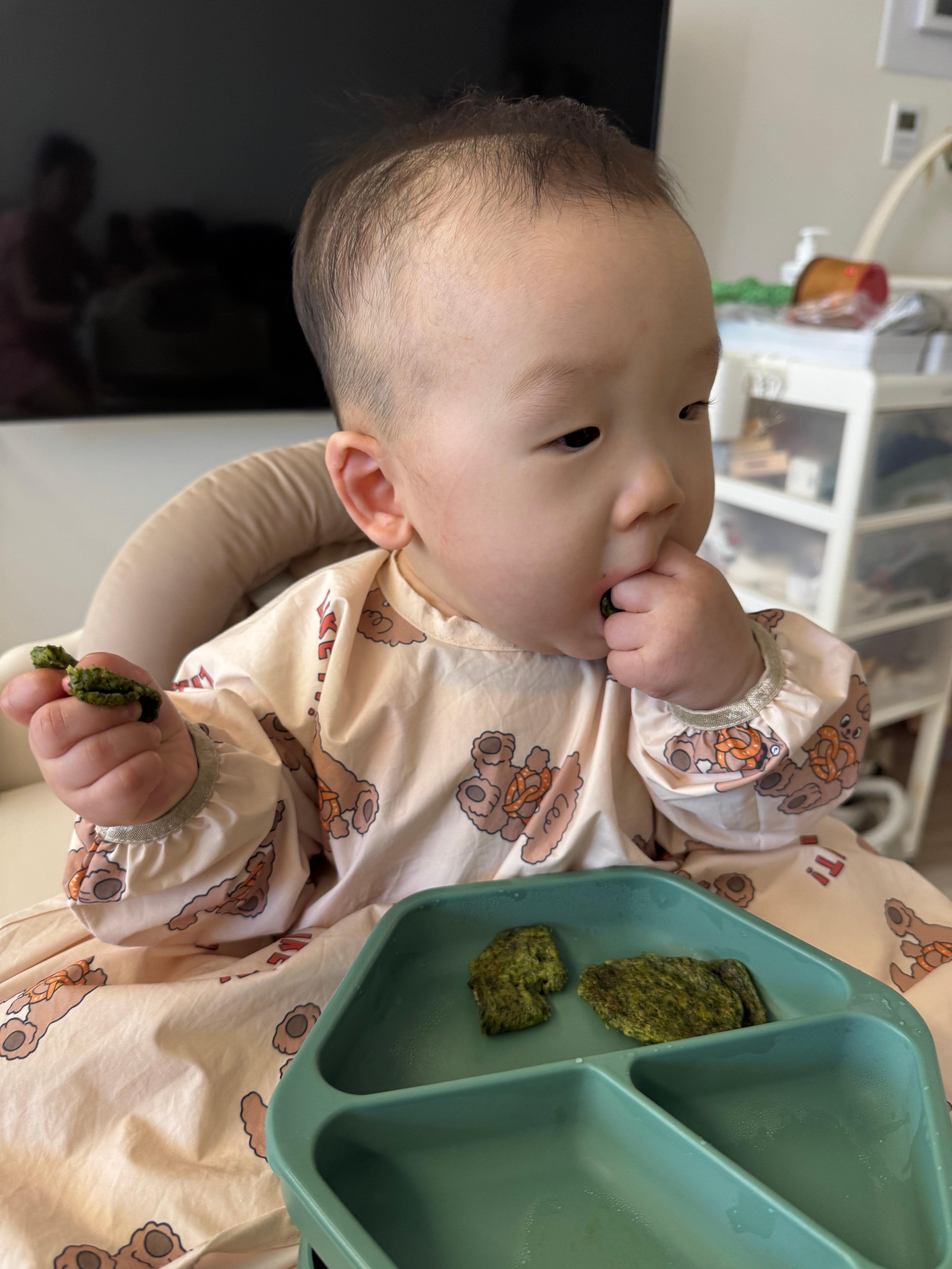 시금치전을 손에 쥐고 스스로 먹고 있는 찬솔이의 저녁 자기주도 식사 모습