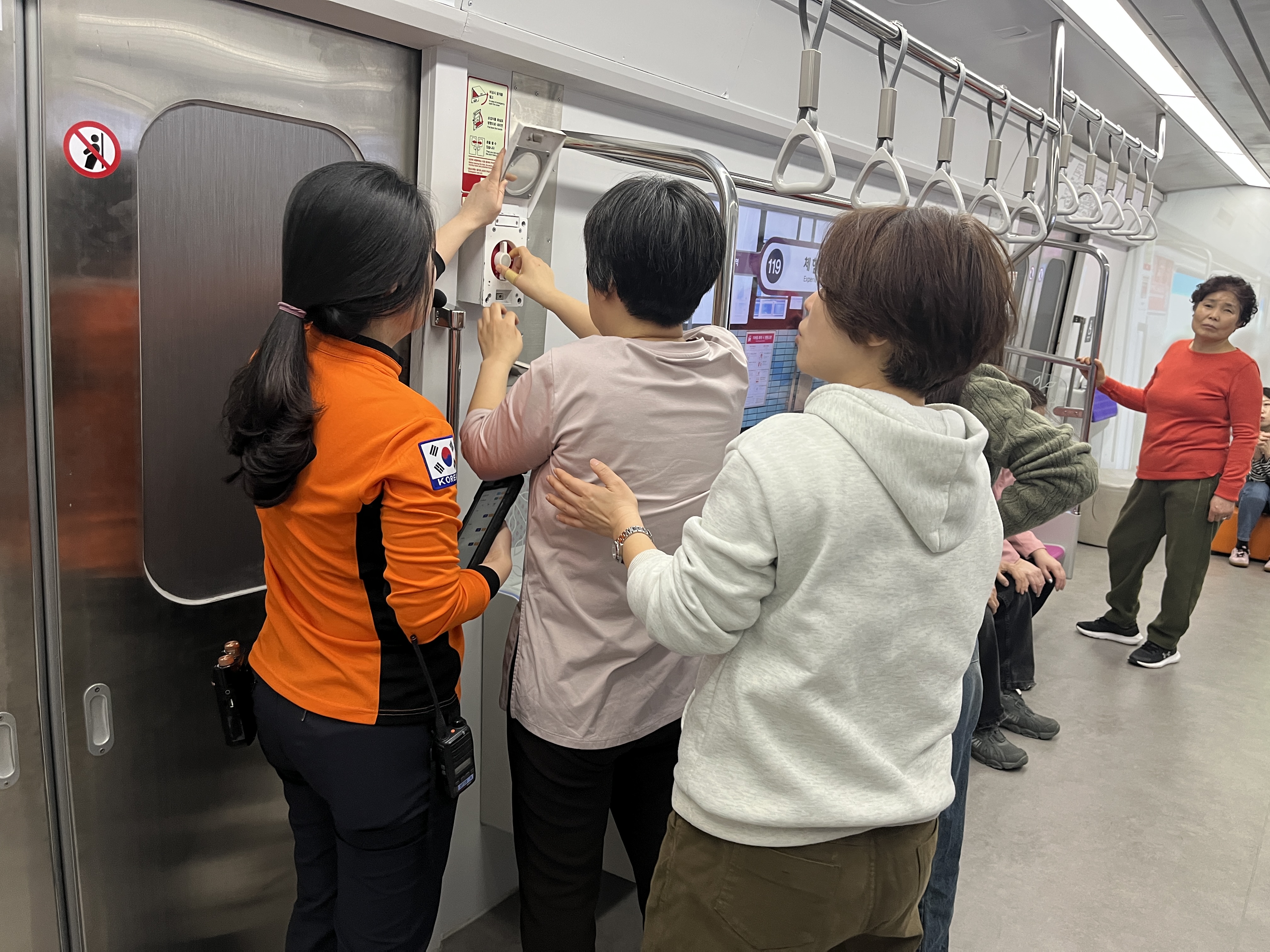 지하철 문을 수동으로 여는 방법을 소방원이 설명하고 있다.