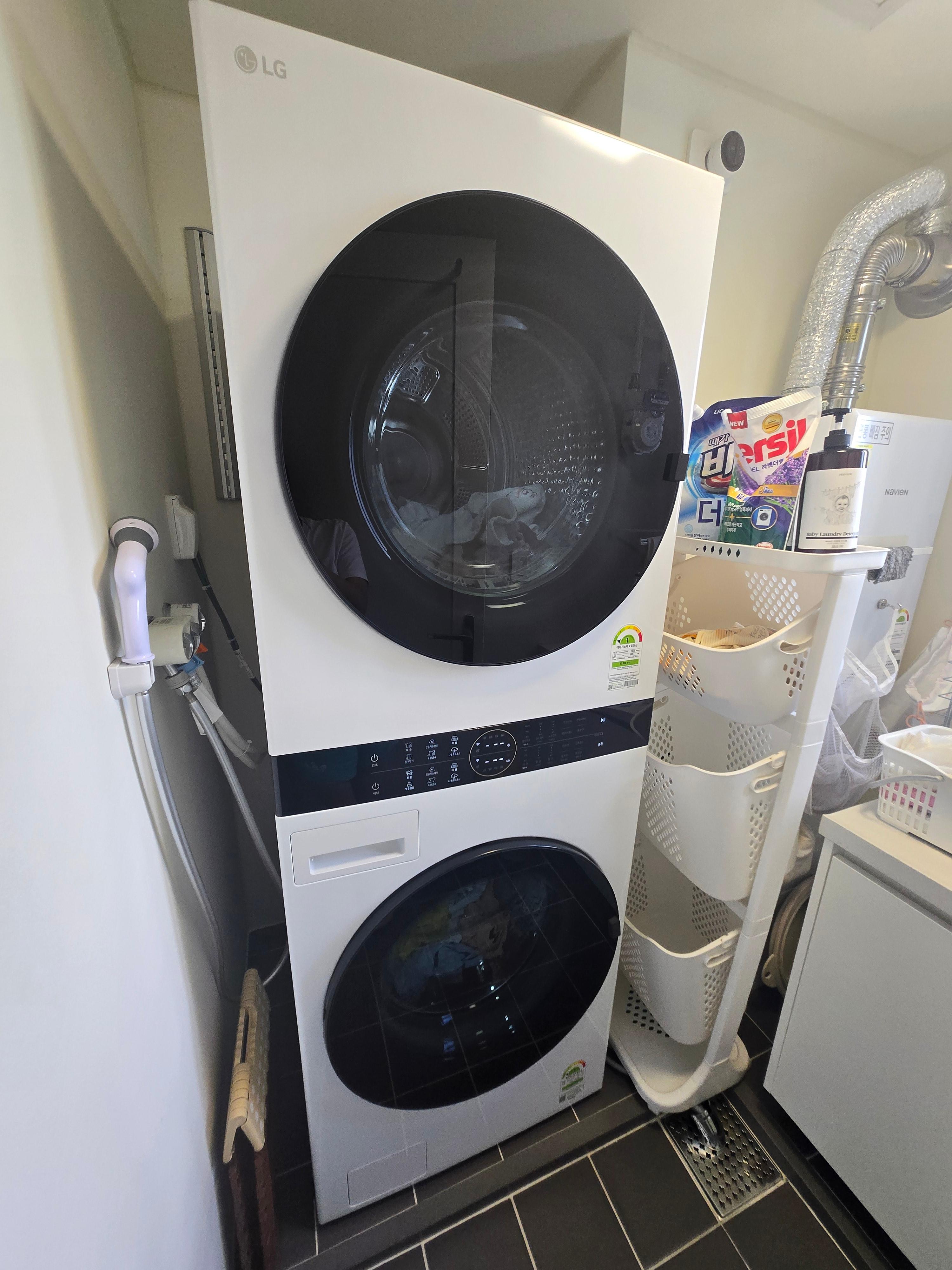 세탁실 벽에 설치된 LG 워시타워 W20WHN과 그 옆에 수납 선반이 함께 있는 모습