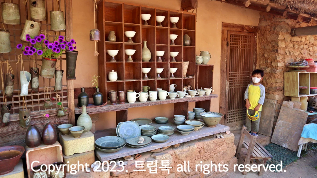 초가집 밖에 빼곡하게 있는 도자기 작품들