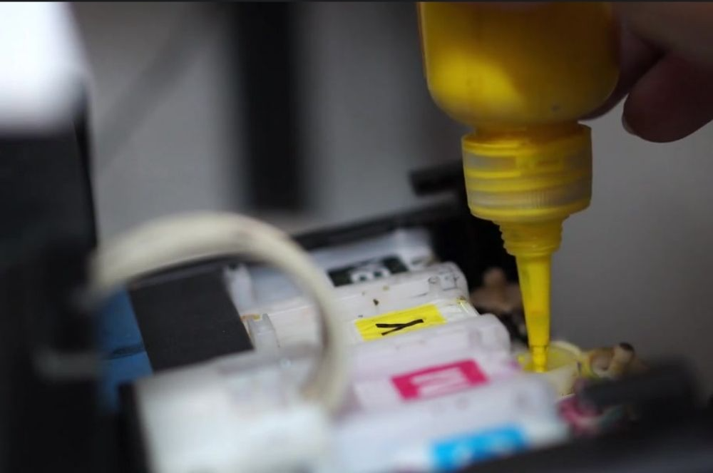 잉크젯 프린터기에 잉크를 리필하는 장면