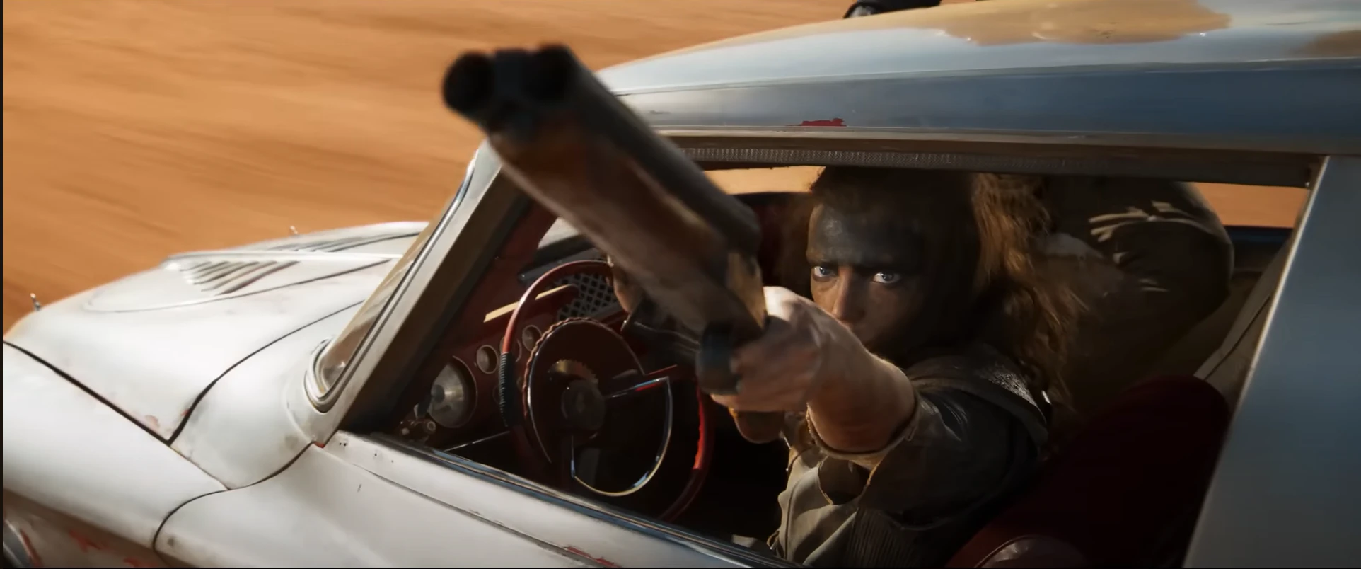 퓨리오사 영화에서 자동차에서 총을 겨누는 퓨리오사