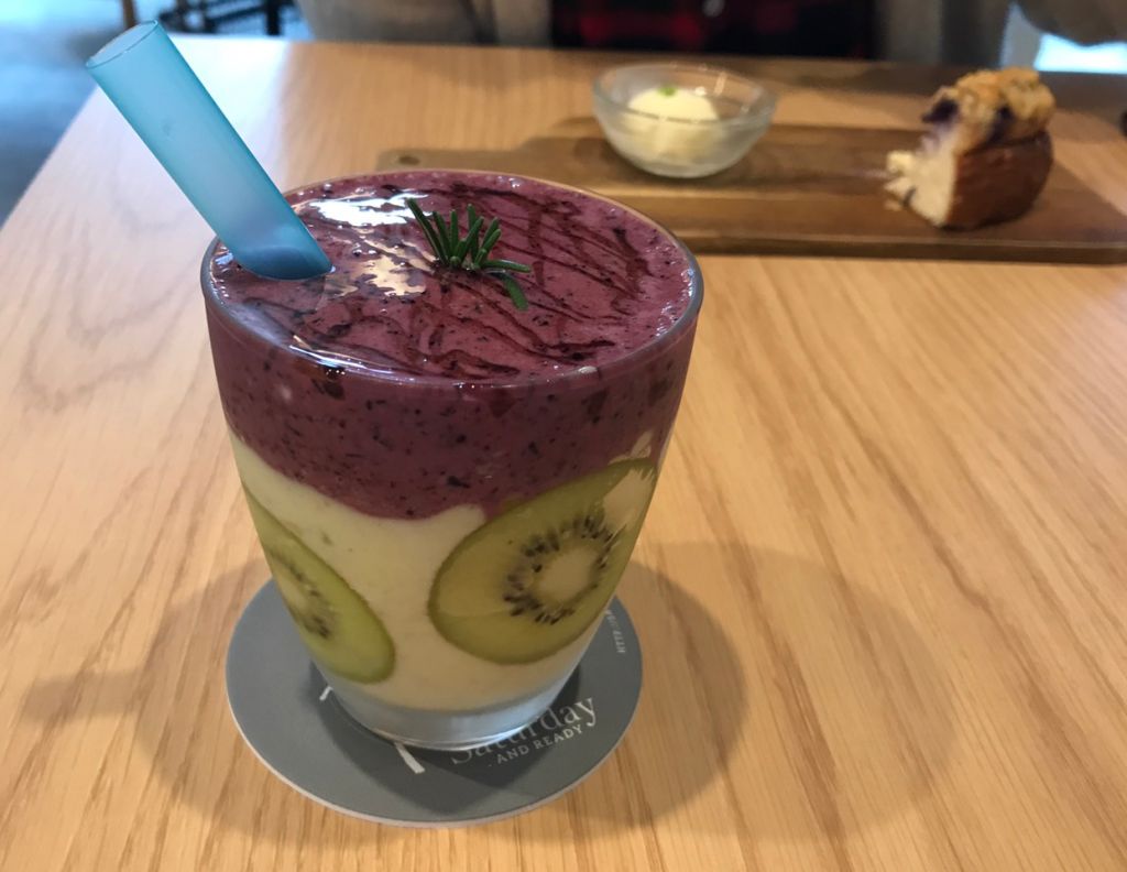 후쿠오카 새러데이 앤 레디 키위&#44; 블루베리 스무디 사진입니다. 컵 벽쪽에 키위가 붙어있고 위쪽에 블루베리 스무디가 올려져있습니다.