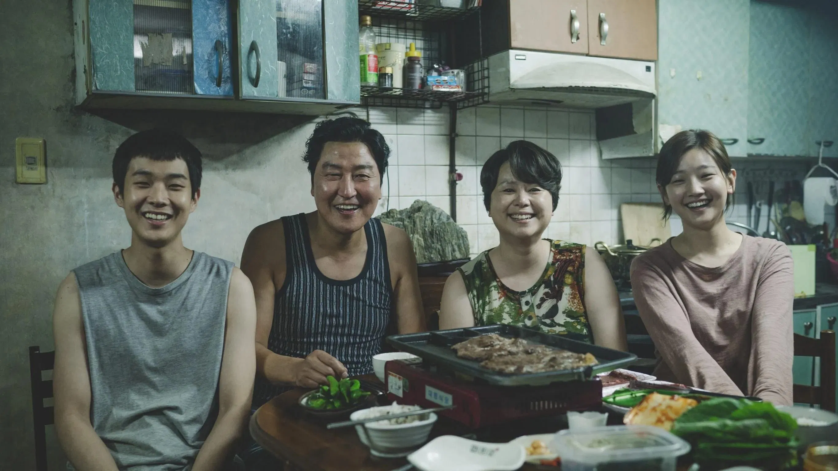 기생충 영화에 나오는 4명의 가족이 환하게 웃고 있는 모습