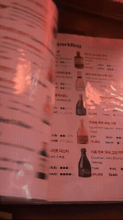 논현동 비노비스 와인바의 와인 메뉴판을 넘기는 장면 gif. 다양한 와인 종류가 정리되어 있는 모습이 보인다.