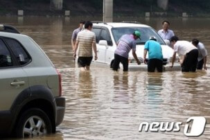 침수된-차를-사람들이-들어올리는-사진