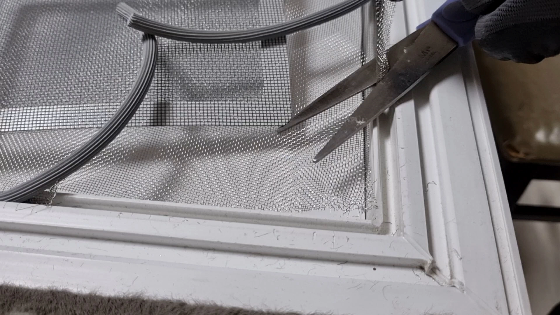 찢어진 방충망 잘라내는 모습