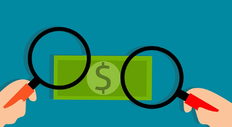 지폐를 돋보기로 확대하는 이미지