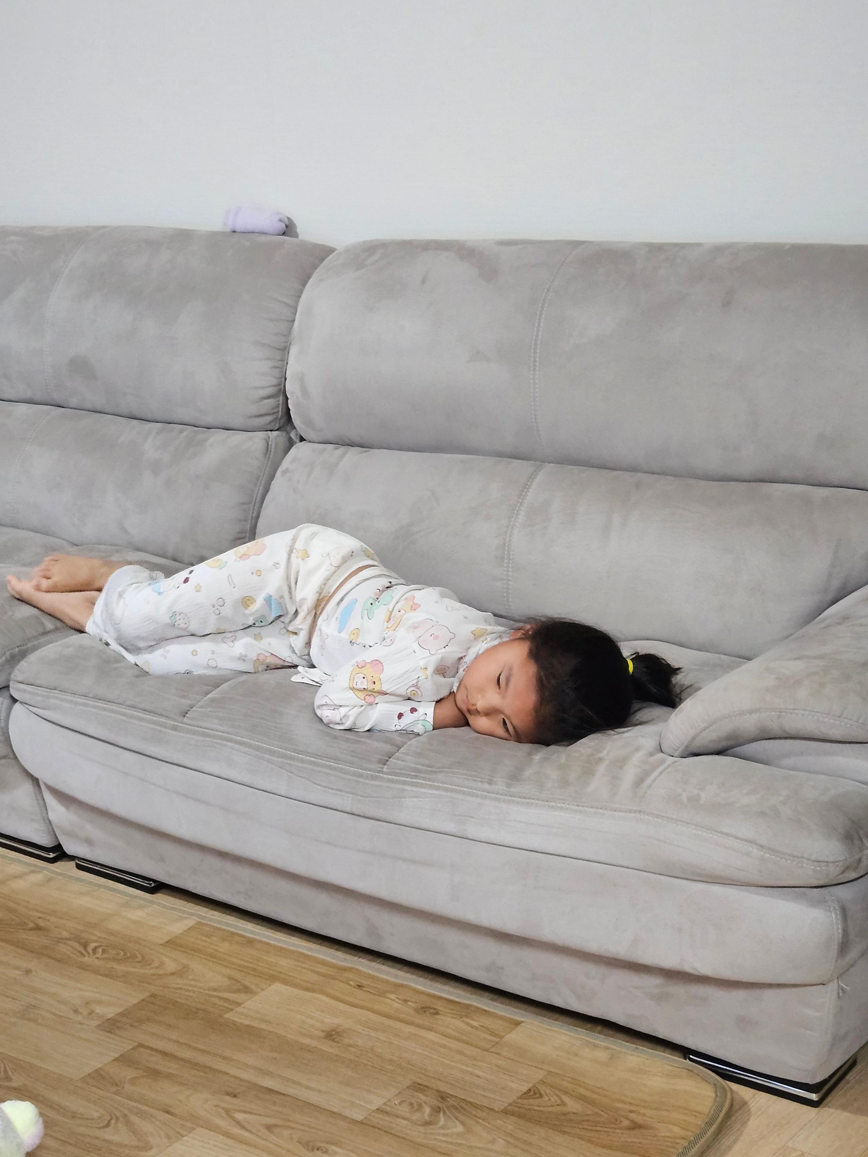 소파에 엎드려 곤히 잠든 초등학생 아이의 뒷모습 사진