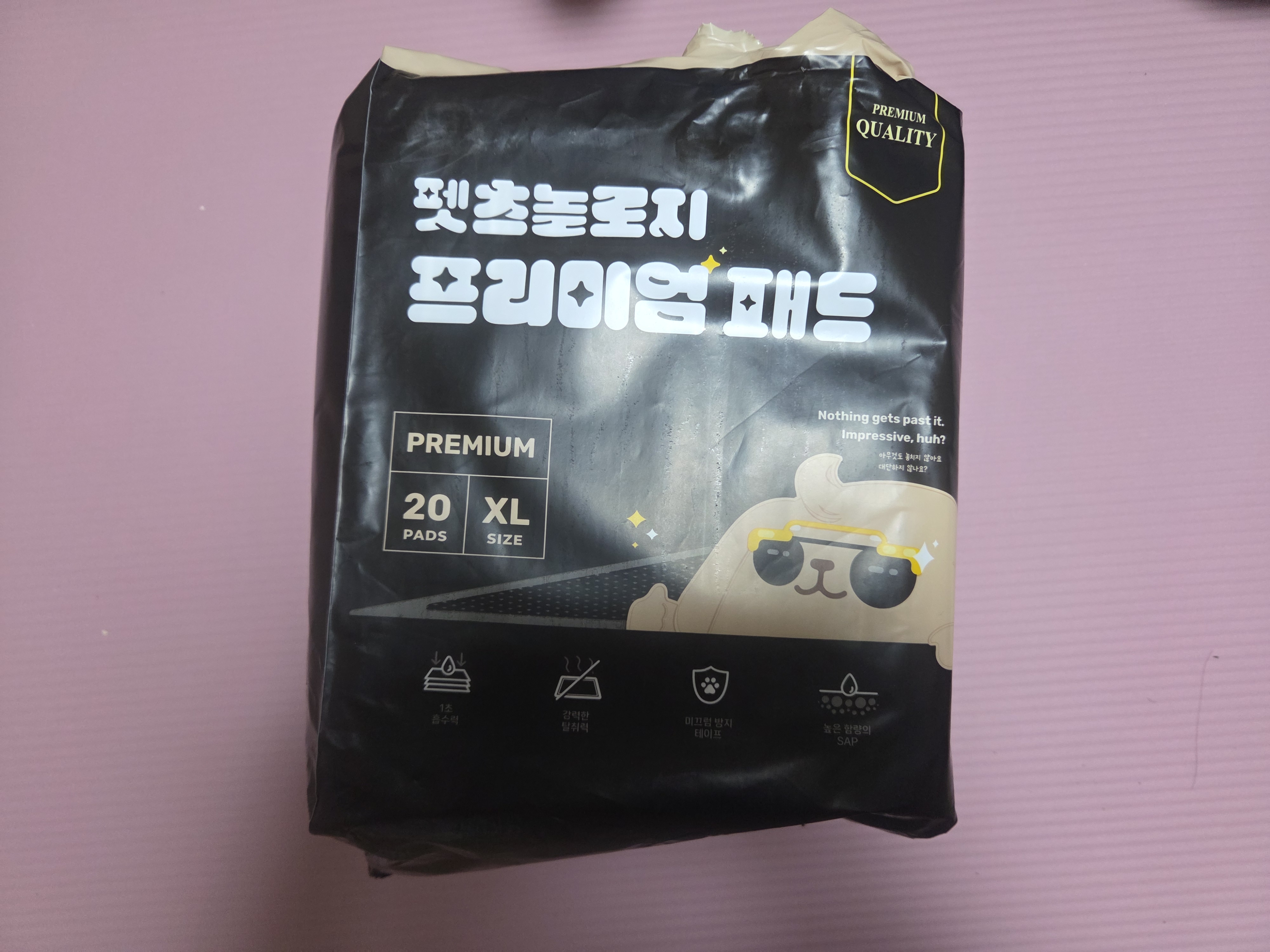 펫츠놀로지 프리미엄 배변패드 XL 사이즈 20매입 패키지 겉모습. 강력한 흡수력과 탈취력을 강조하는 검은색 포장지 디자인이 돋보이는 제품 사진입니다.