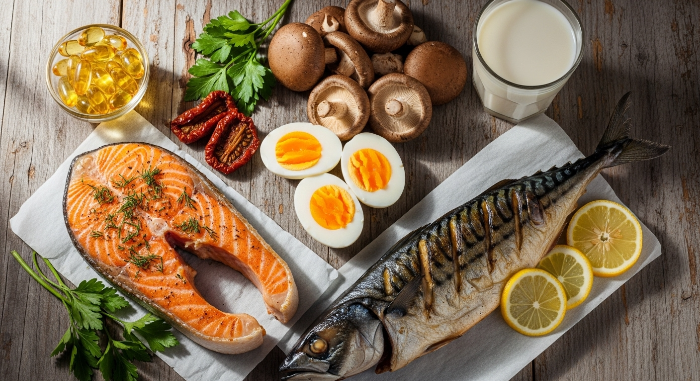 연어, 고등어, 버섯, 달걀 등 비타민D가 풍부한 건강 식품들이 놓인 이미지.