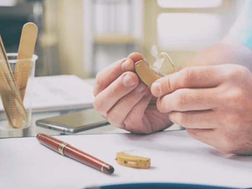 손으로-잡고-있는-보청기