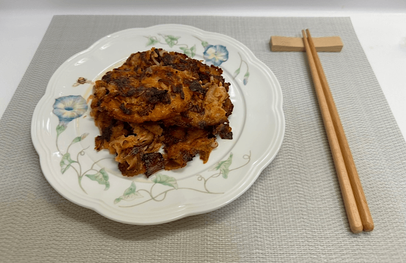 꽃무늬 접시에 담긴 찢어진 김치전과 나무젓가락 세팅