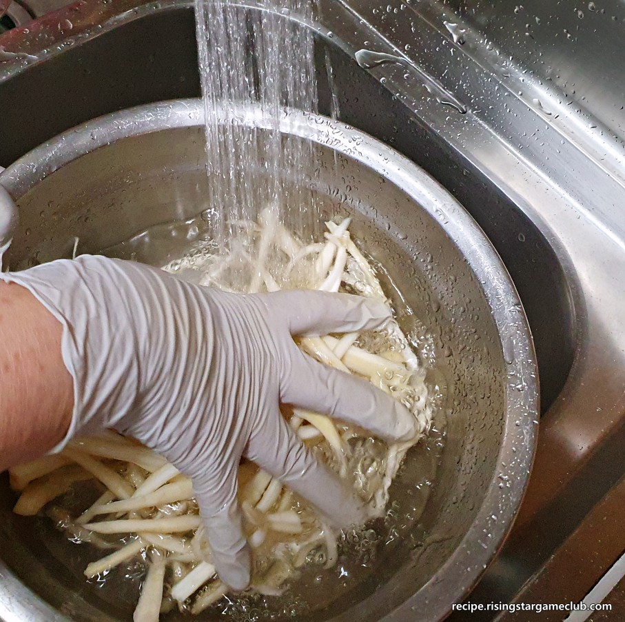 도라지나물에 들어갈 소금을 넣은 도라지에 물을 넣으면서 손으로 섞어주는 사진