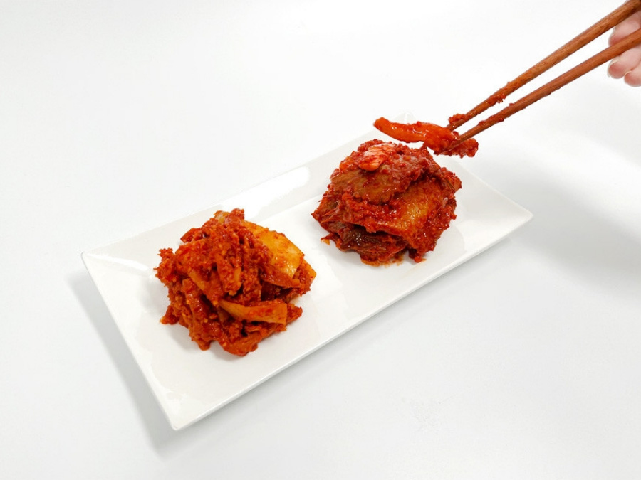 바다에서 채취를 한 가자미를 잘 손질하고 잘라서 곡류와 고추가루를 넣고 발효시켜 만든 가자미색해를 네모낳고 하얀 그릇에 2덩이를 놓고 젓가락으로 한점 집는 것을 찍은 사진