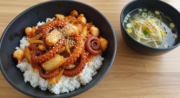 낚지볶음덥밥과 콩나물국이 놓여 있다.