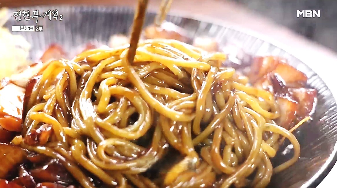 금문도의 강화속노랑간짜장을 맛있게 비비고 있는 전현무계획2 방송 장면