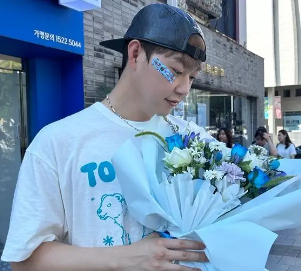 싱어게인3- 꽃다발을 들고 흰티를 입고 검은야구모자를 뒤집어 쓴채 꽃을 바라보는 40호