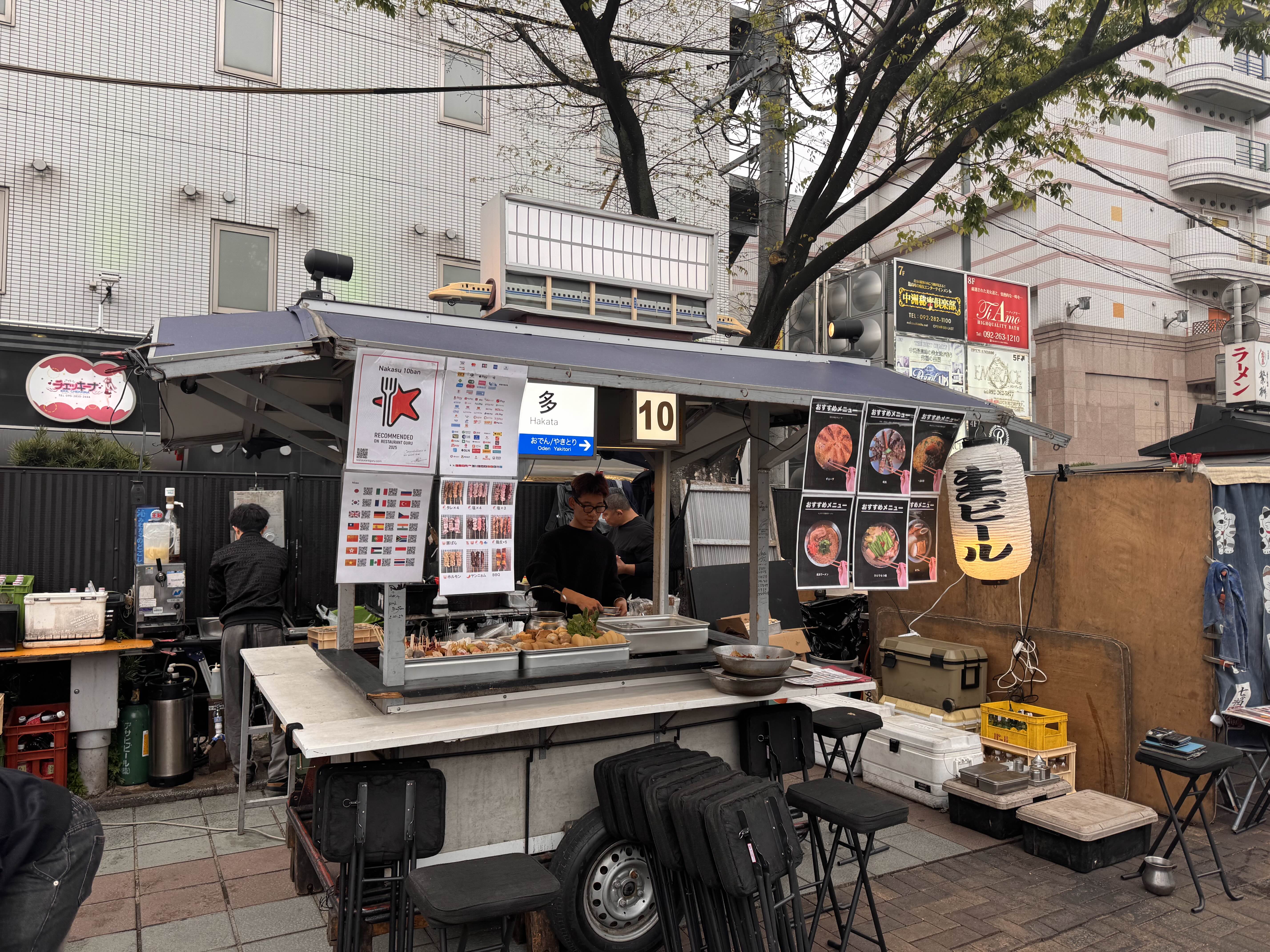 일본 후쿠오카 길거리에 자리 잡은 고즈넉한 분위기의 전통 포장마차 야타이와 주변 도심 풍경