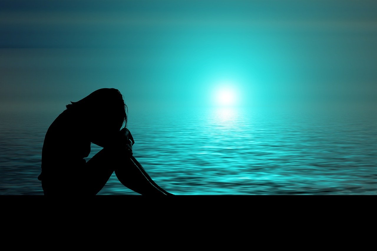 어둡고-고독한-바닷가에서-웅크리고-앉아있는-여성