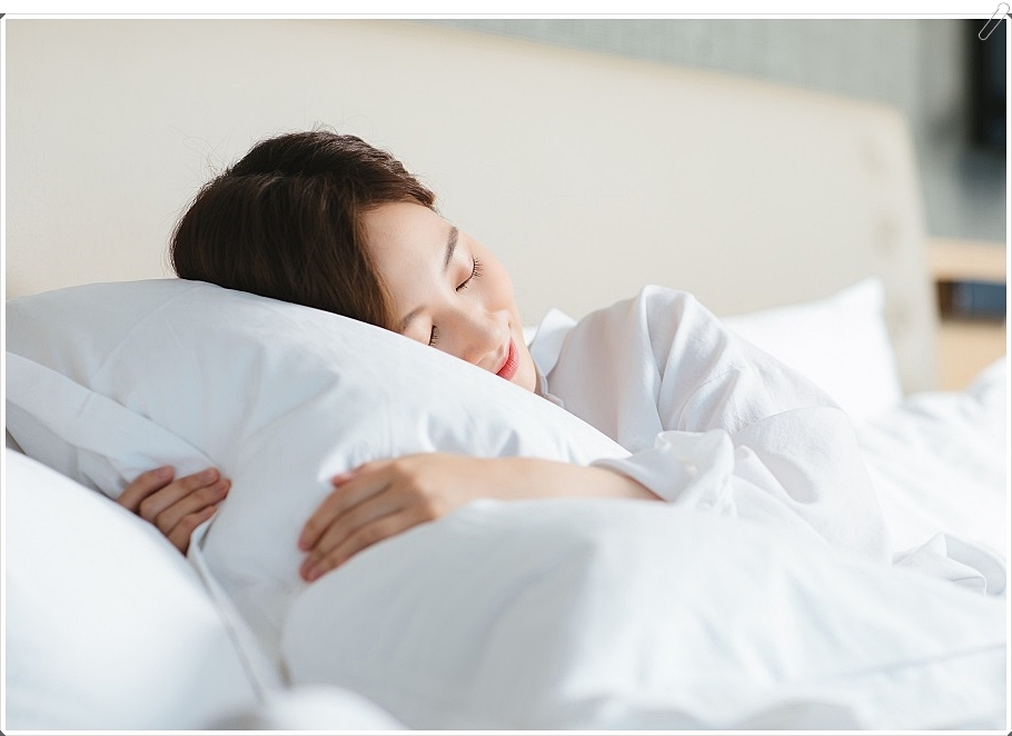 미소를 띄며 잠을 자고 있는 여성의 모습