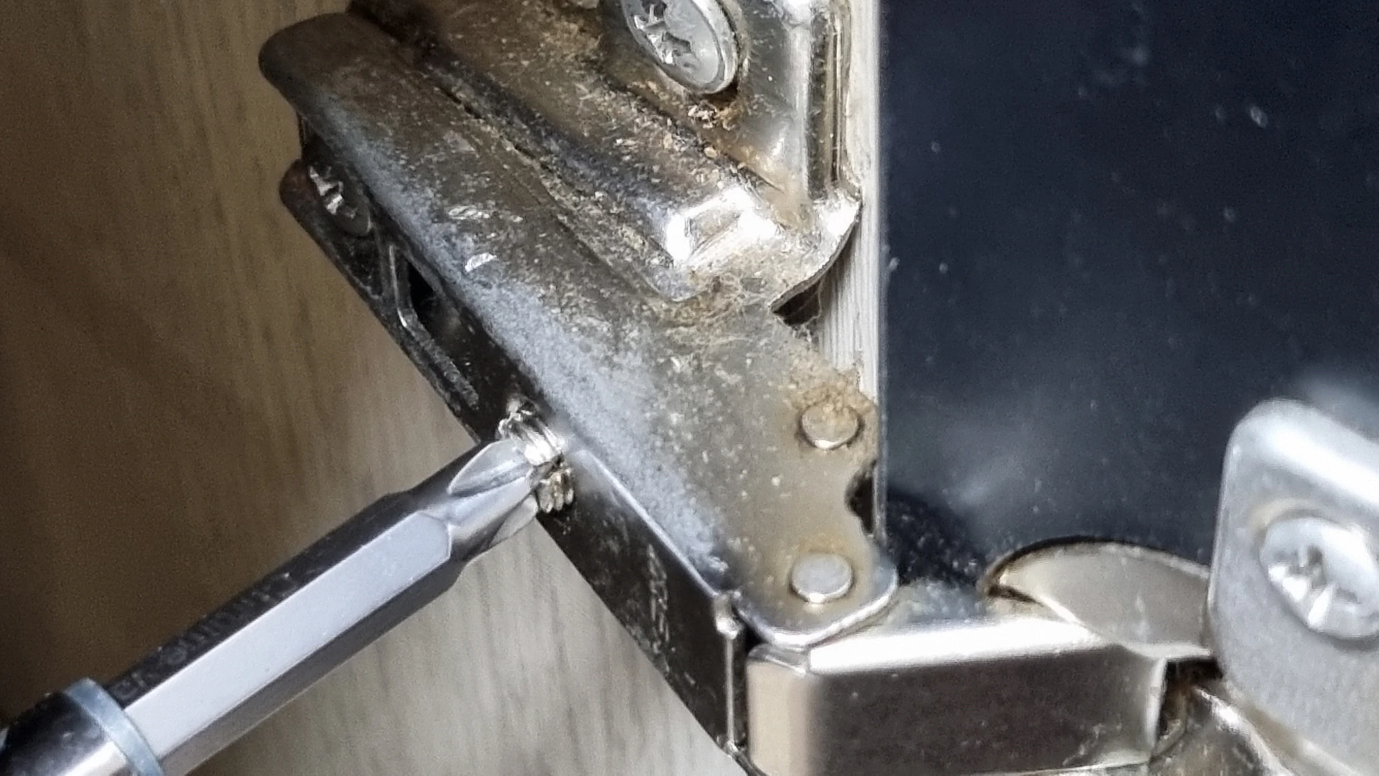 경첩 조절 볼트 돌리는 모습