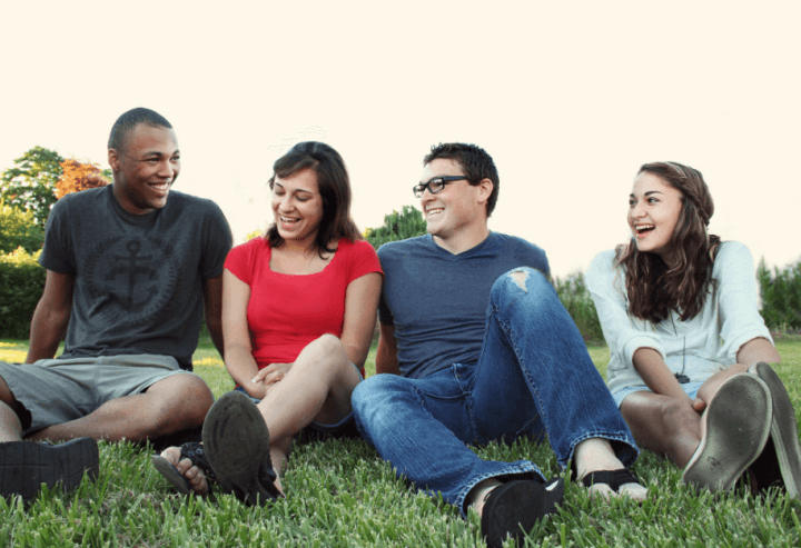 잔디에 앉아 웃고있는 네 명의 남녀
