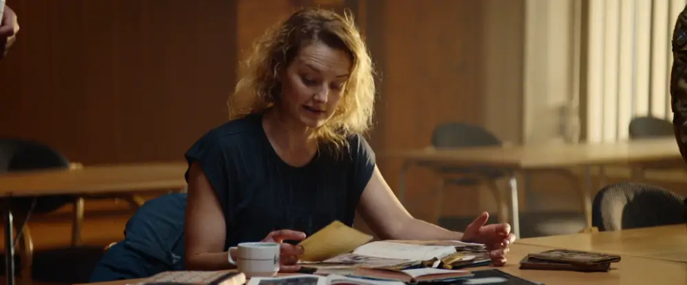 책상위에 자료들을 보고 있는 로라