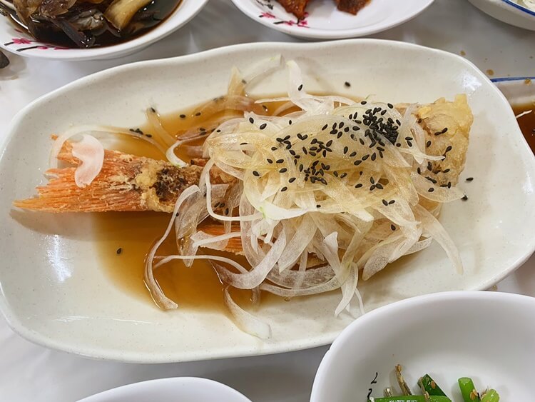 생선튀김위에 채 썬 양파에 간장 소스가 뿌려진 요리이다