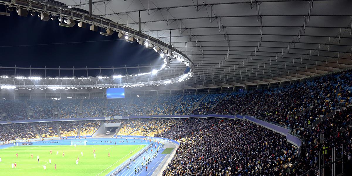 관중석을 가득 채운 팬들이 응원하는 대형 축구 경기장 전경